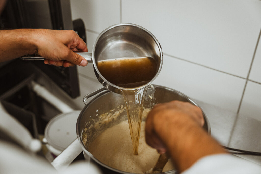 Brühe wird in Topf gegossen, um Meerrettich herzustellen